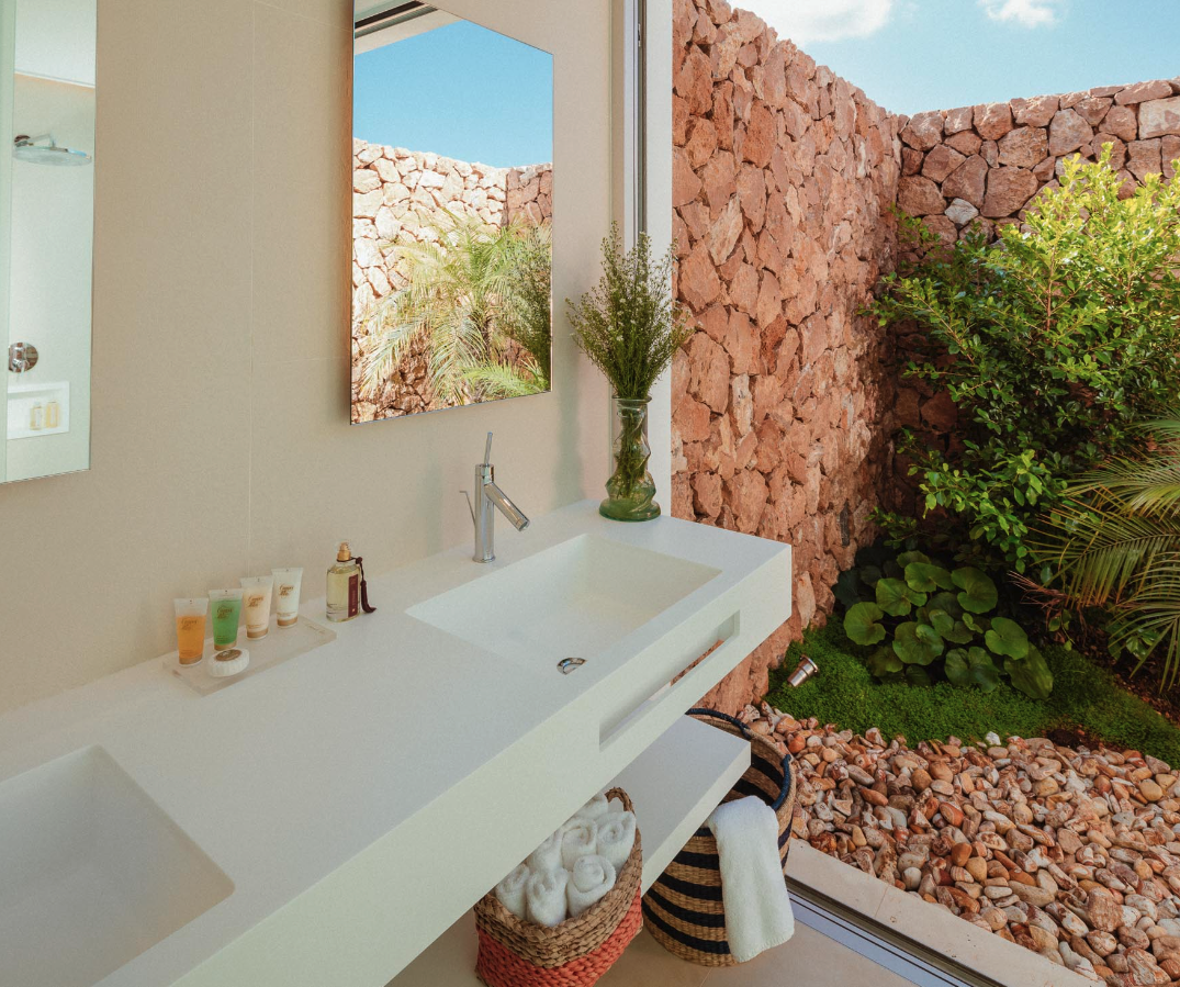 Baño con pared de piedra y jardín
